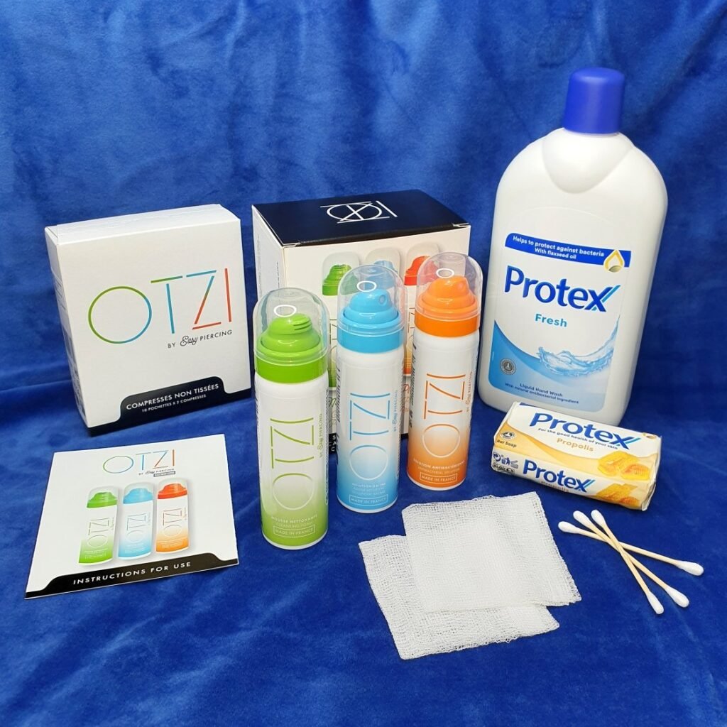 Piercing aftercare kit: OTZI antibacterial soap, saline solution, antibacterial solution, gauze, cotton swabs, and Protex antibacterial soaps.